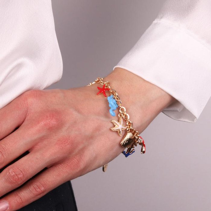 Bracelet en métal avec étoile de mer, coquillages, ancre et gouvernail